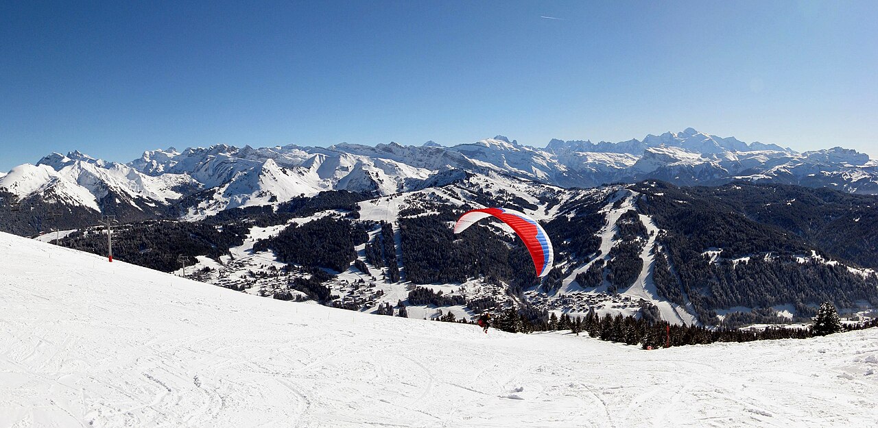 Panorama enneigé des Gets en février 2010, avec une voile de parapente ; illustration du paysage du domaine.